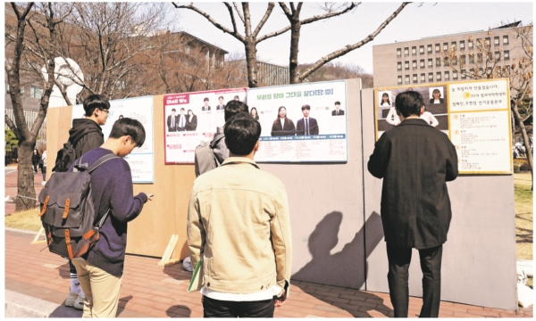 학생들이 오프라인 게시판에 게시된 선본들의 공고 포스터를 읽고 있다. 2019학년도 보궐선거 선거운동은 지난달 19일(화)부터 시작됐으며 오늘 1일(월)부터 보궐선거 투표가 시작된다.