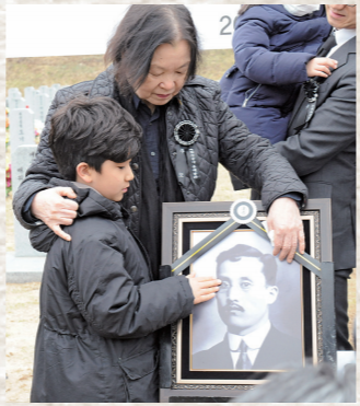 안장식을 마친 김태연 애국지사의 유가족이 영정사진을 어루만지고 있다.