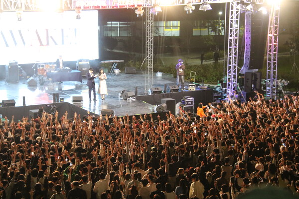 메인 스테이지에서 학생들이 MC 호응에 따라 손을 들고 있다.