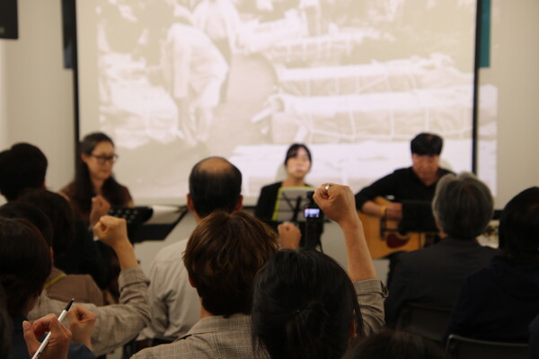 ‘임을 위한 행진곡’이 나오며, 관객들이 손을 치켜들고 노래를 따라부르고 있다.