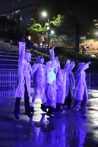 학생들이 비가 오는 날씨에도 우비를 입고스탠딩존에서 공연을 즐기고 있다.